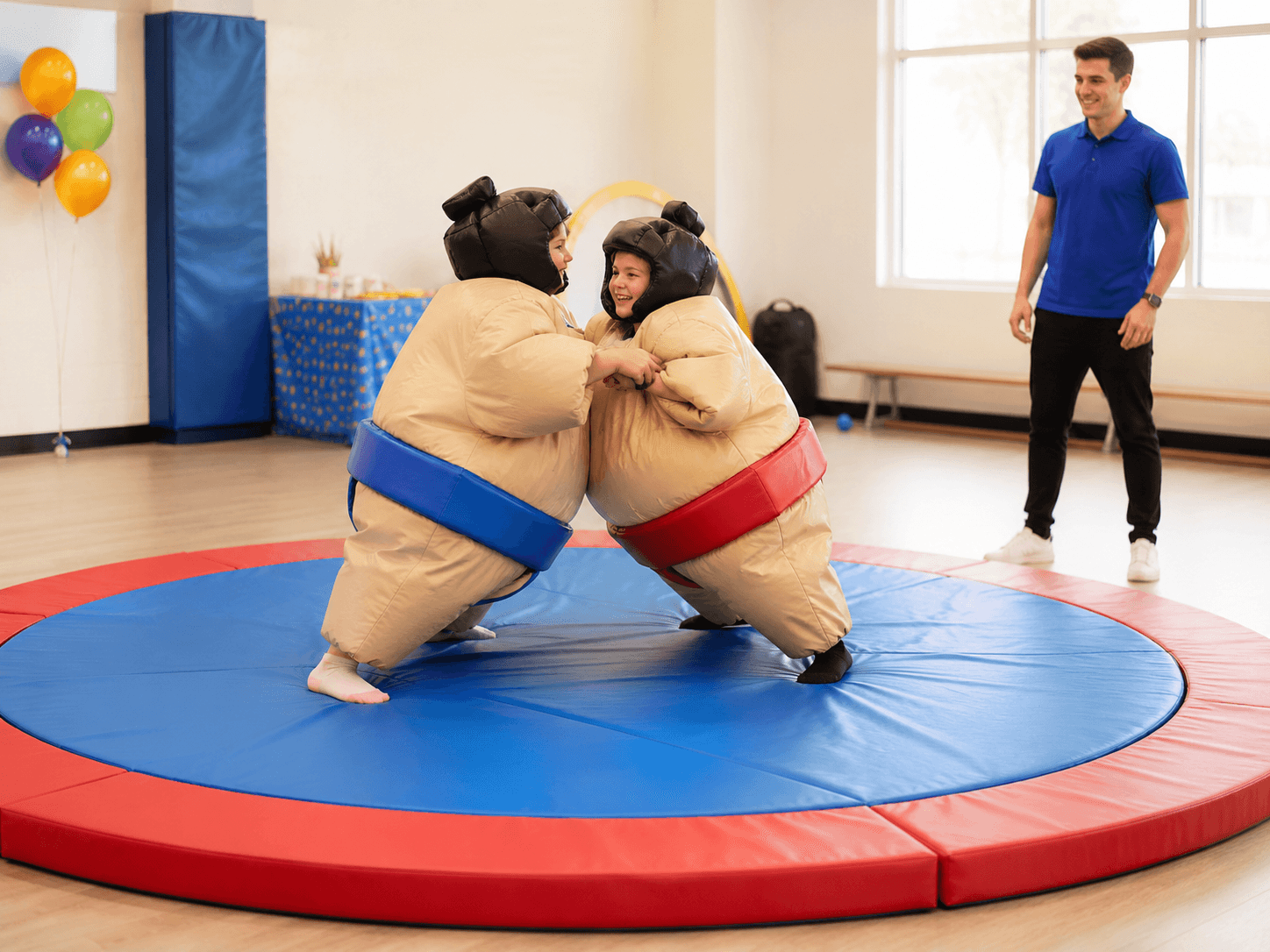 Children using padded sumo suits inside a designated activity area